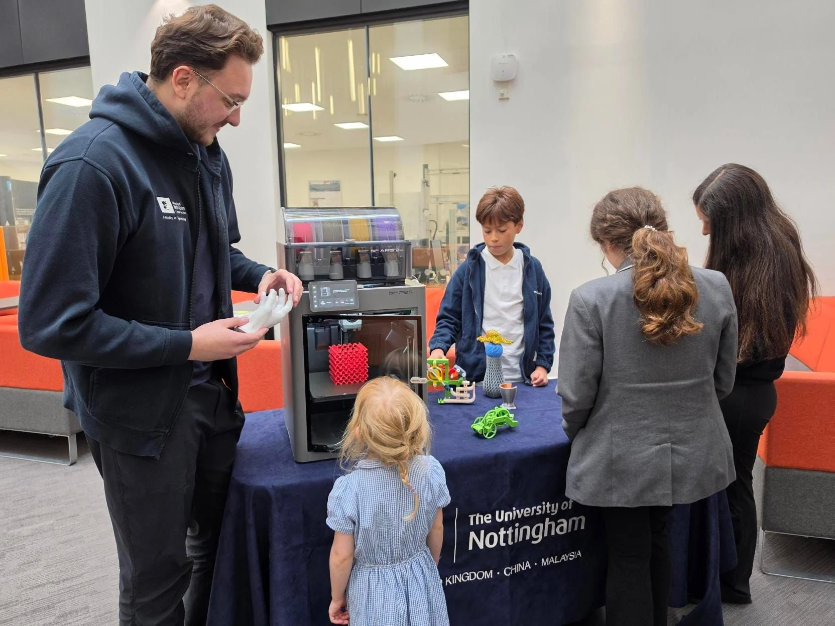 3D printing demonstration at the University of Nottingham with children examining 3D printed objects